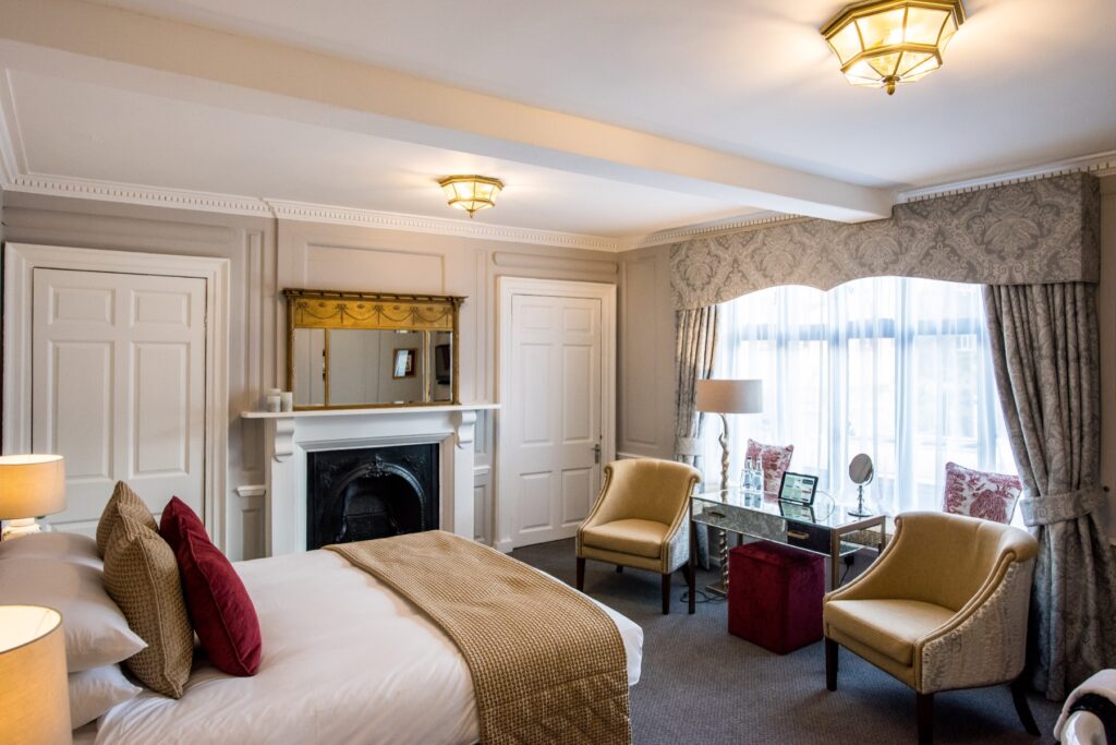 The bed, fireplace and sitting area of the Erpingham Gate Suite