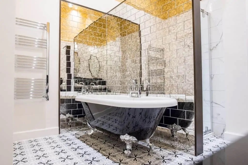 A black roll-top bath in the marble bathroom