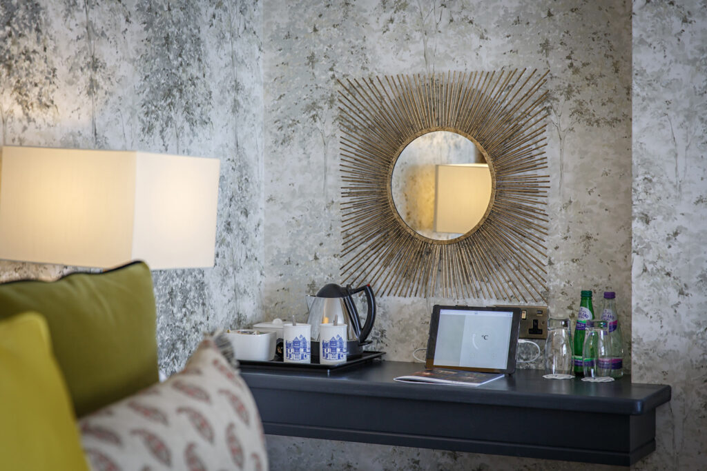 A tea tray and sunburst mirror on a dark wooden console