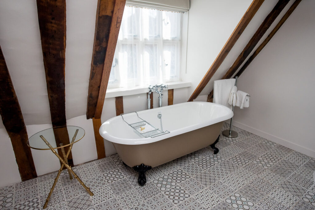 A roll-top bath beneath a window in the eaves