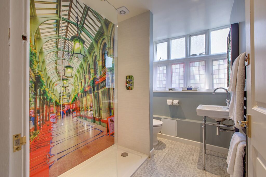 A walk-in shower beside a colourful painted mural