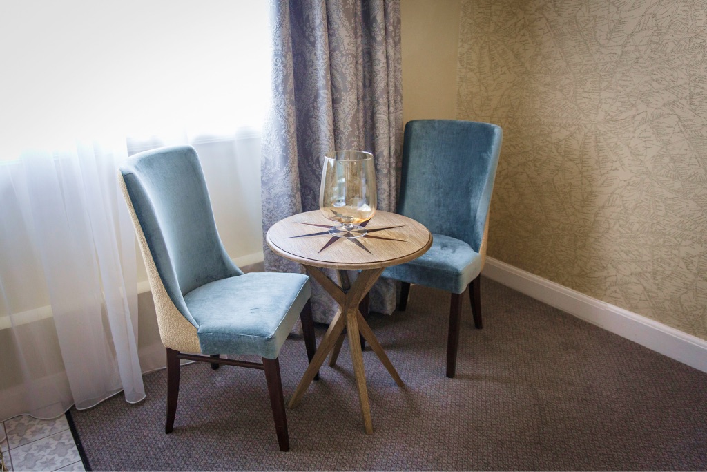 Two blue velvet chairs at a small round table